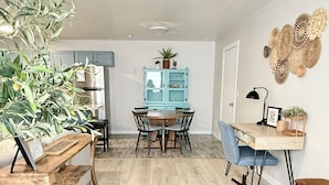 A modern kitchen with a dining area, wooden flooring, and a blue cabinet. - Restful Nest A 3bd&2ba in Midtown Anchorage (Anchorage)