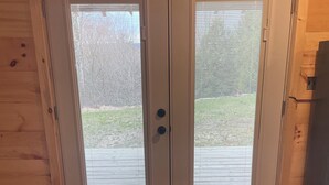 Una puerta de madera con dos paneles de vidrio y un picaporte.