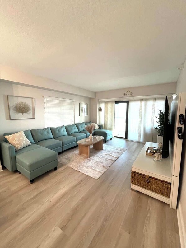Una sala moderna con un sofá modular, una mesa de centro y un televisor.