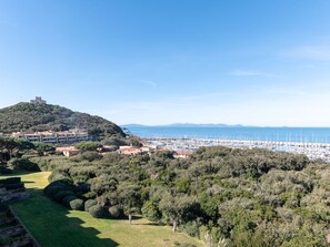 A coastal town with a hilltop castle, marina, and lush greenery. - Il Veliero by Interhome (Punta Ala)