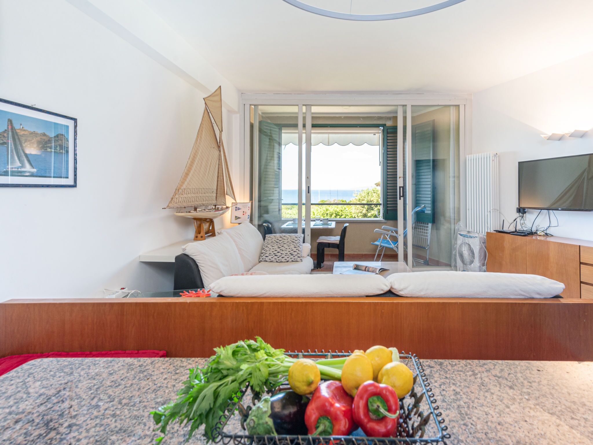Ein gemütliches Zimmer mit einer Couch, einem kleinen Tisch und einem Fenster mit Meerblick.