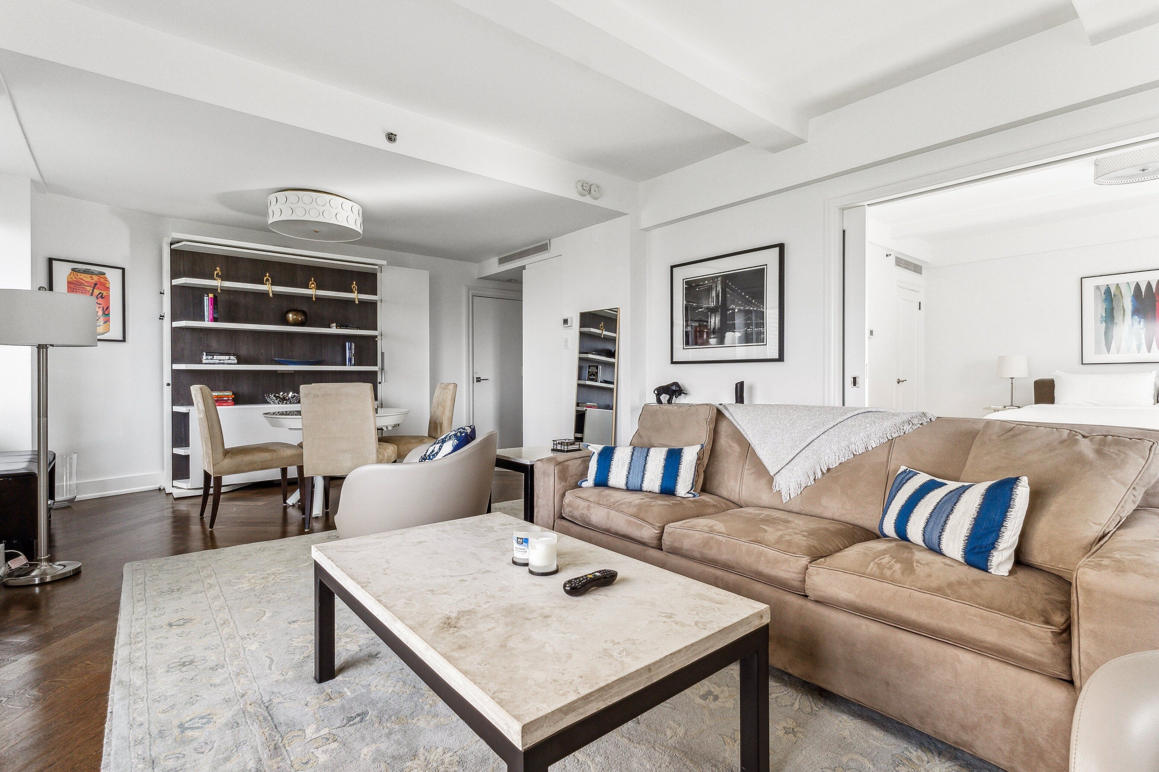 A living room with a beige sofa, a coffee table, and a bookshelf.