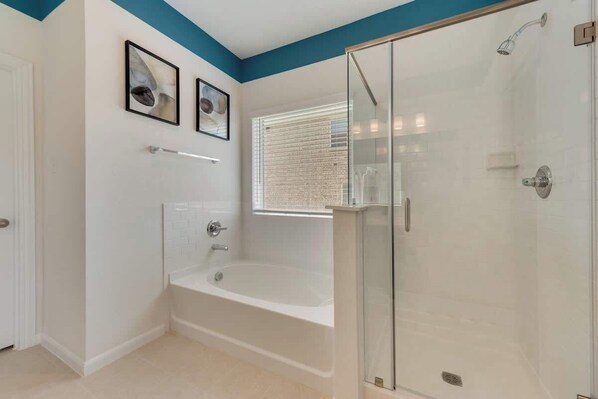 A modern bathroom with a glass-enclosed shower, a freestanding bathtub, and two framed artworks on the wall. - Nexsphere Suites, 4Bdr WIFI Outdoor Heating, Grill (Sherman)
