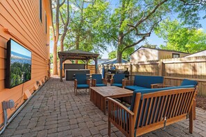 Relax outdoors with a comfortable patio featuring a wooden table and cushioned chairs.