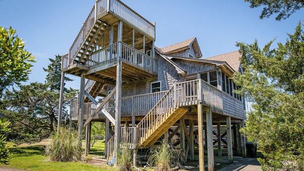 Ein mehrstöckiges Holzhaus mit Balkon und Treppe.