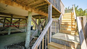 Eine Holzterrasse mit einer Treppe, die zu einer erhöhten Ebene führt.
