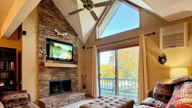 A cozy living room with a fireplace, leather sofas, and a ceiling fan. - Not Your Everyday Mini Chalet, foot of Holiday Valley Resort! Walk to Downtown (Ellicottville)