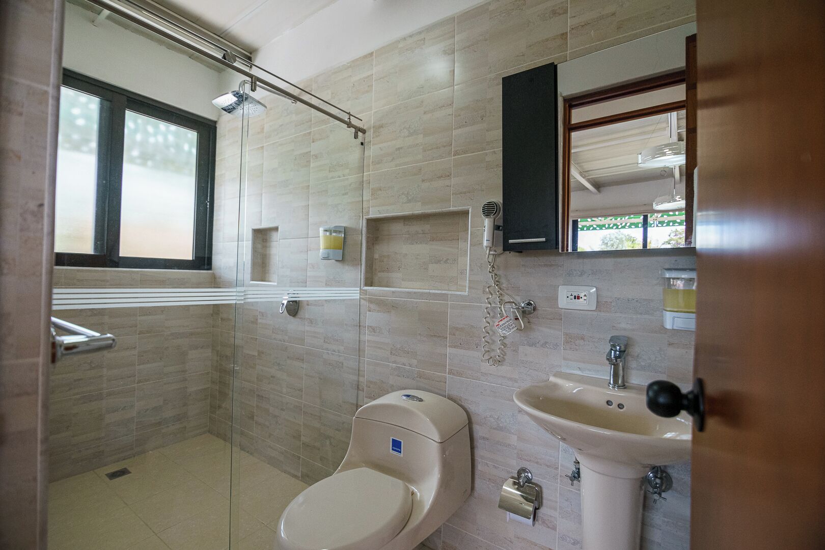 Un baño con inodoro, lavabo y ducha.