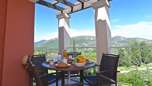 A balcony with a table set for breakfast, overlooking a mountainous landscape. - L'Esquinade (G1 203) by Interhome (Agay Village Cap Esterel)