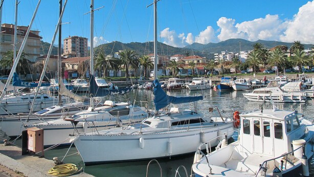 A marina with various boats docked, a clear sky, and buildings in the background. - Il Castagneto by Interhome (Arma di Taggia)