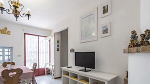 A living room with a television, a map on the wall, and a bookshelf. - Il Castagneto by Interhome (Arma di Taggia)