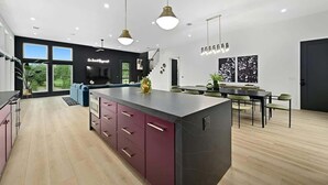 Een moderne keuken met een centraal eiland, inbouwmeubels en hanglampen.