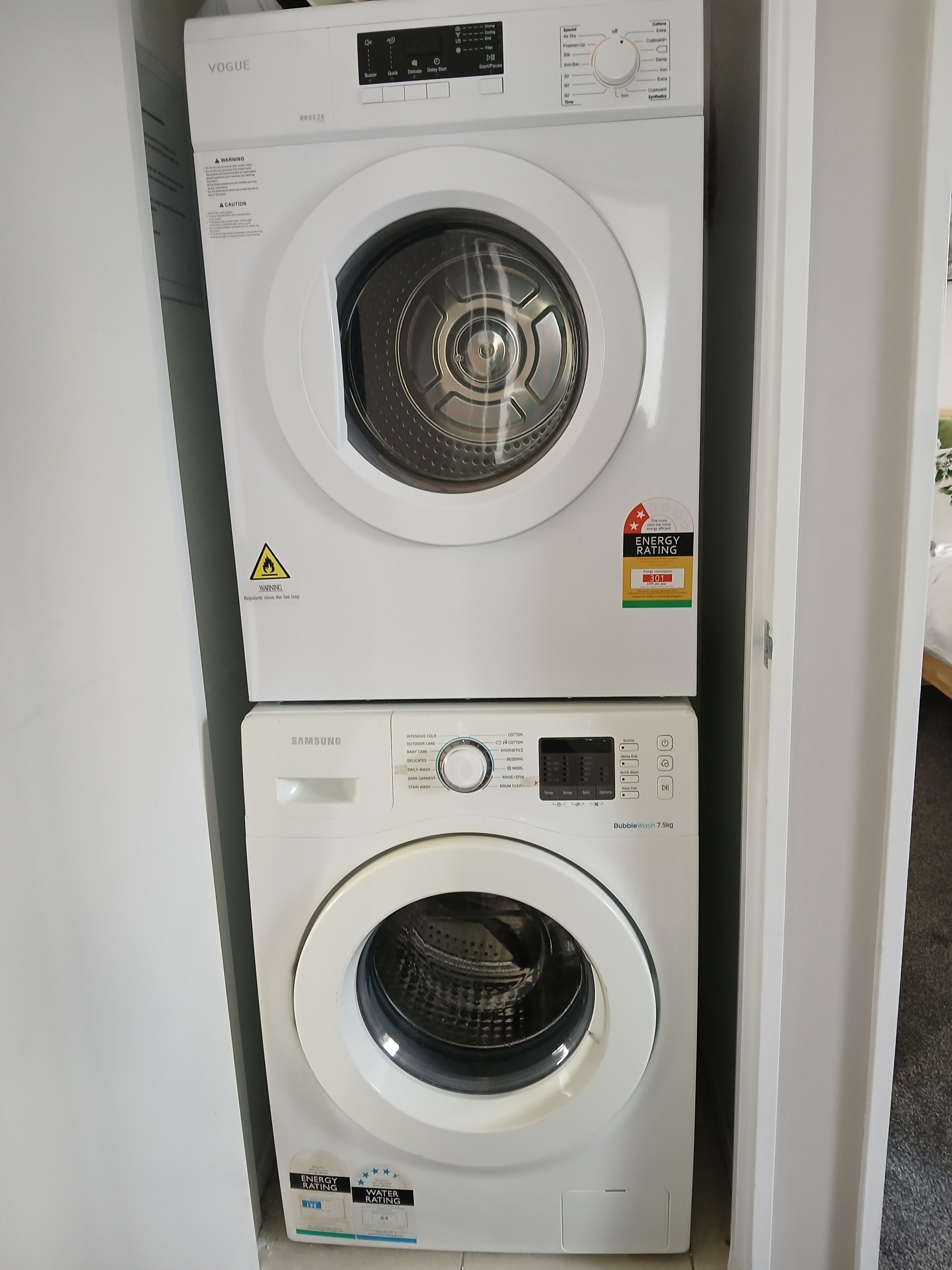 A stacked washer and dryer unit with energy and water efficiency ratings.