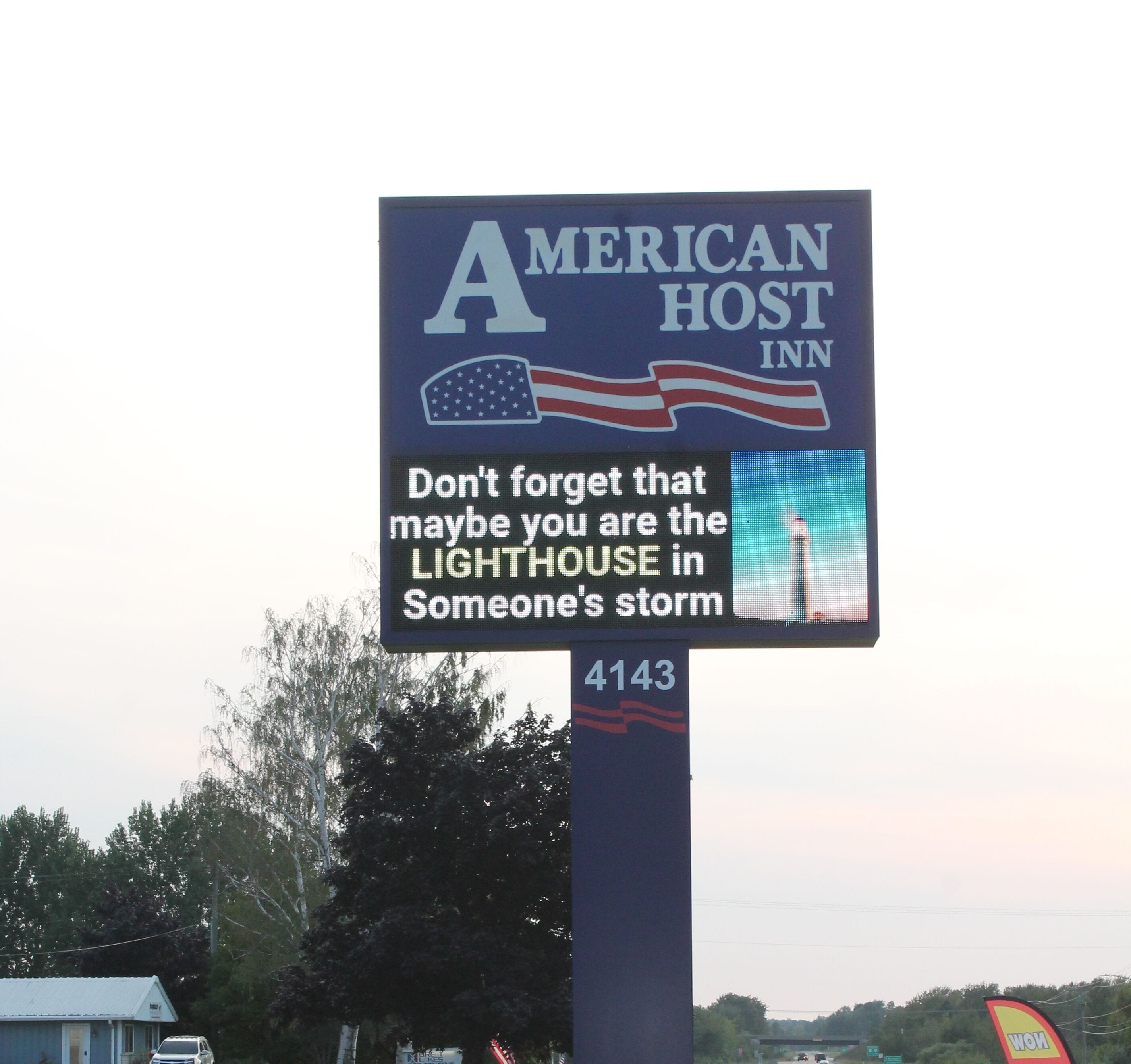 A sign for the American Host Inn with a reminder message.