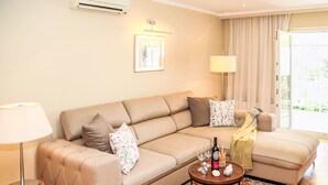 A modern living room with a beige sectional sofa, a round coffee table, and a floral rug.