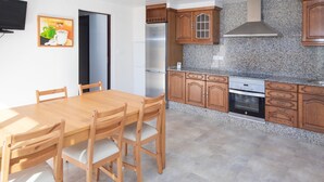 Une cuisine dotée de meubles en bois, d’un réfrigérateur en acier inoxydable, d’un four encastré et d’un plan de travail en granit.