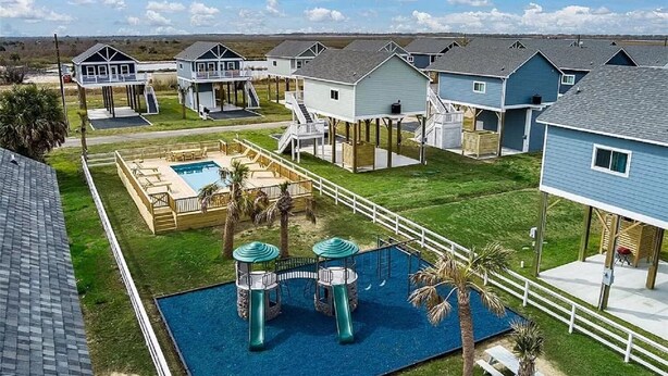 Ett bostadsområde med flera hus, en swimmingpool och en lekplats.