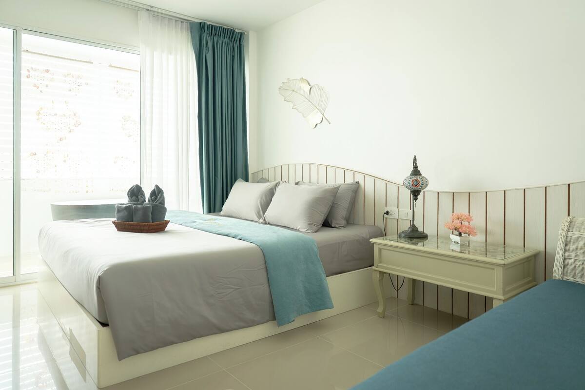 Ein Schlafzimmer mit Bett, Nachttisch, Lampe und einer Wanddekoration.