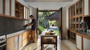 Una cocina moderna con armarios de madera, una isla central y vistas a un jardín.