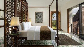 Una cama con dosel con vista a un paisaje tropical a través de un ventanal.