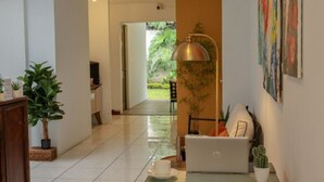 Un intérieur moderne avec un ordinateur portable posé sur une table, une plante en pot et une lampe.