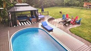 A swimming pool with lounge chairs and a gazebo.