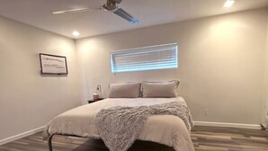A bedroom with a bed, a ceiling fan, a window with blinds, and a framed certificate on the wall. - Luxe Serenity - Remodeled home walking distance from Chapel of the Holy Cross.
 (Sedona)