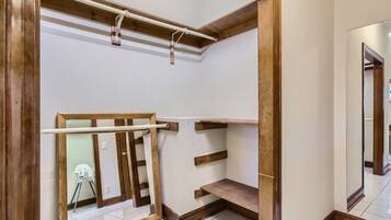 A room with wooden beams, a metal rod, and a wooden ladder.