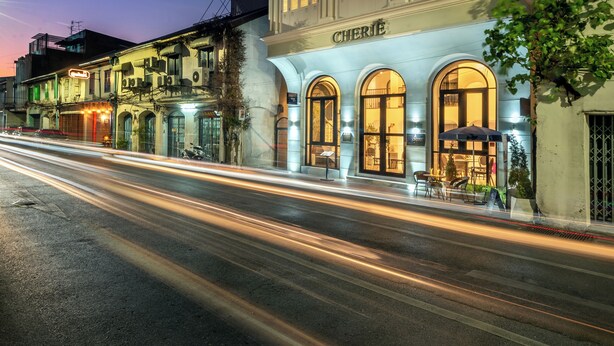 A multi-story hotel with illuminated windows and a sign reading "CHERIE". - Cherie Bangkok Boutique Hotel (Bangkok)