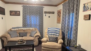 A cozy living room with a sofa, armchair, coffee table, and a small side table. - Hogan’s Hideout Bonnie Manor- Cozy Cottage to enjoy. (Eminence)