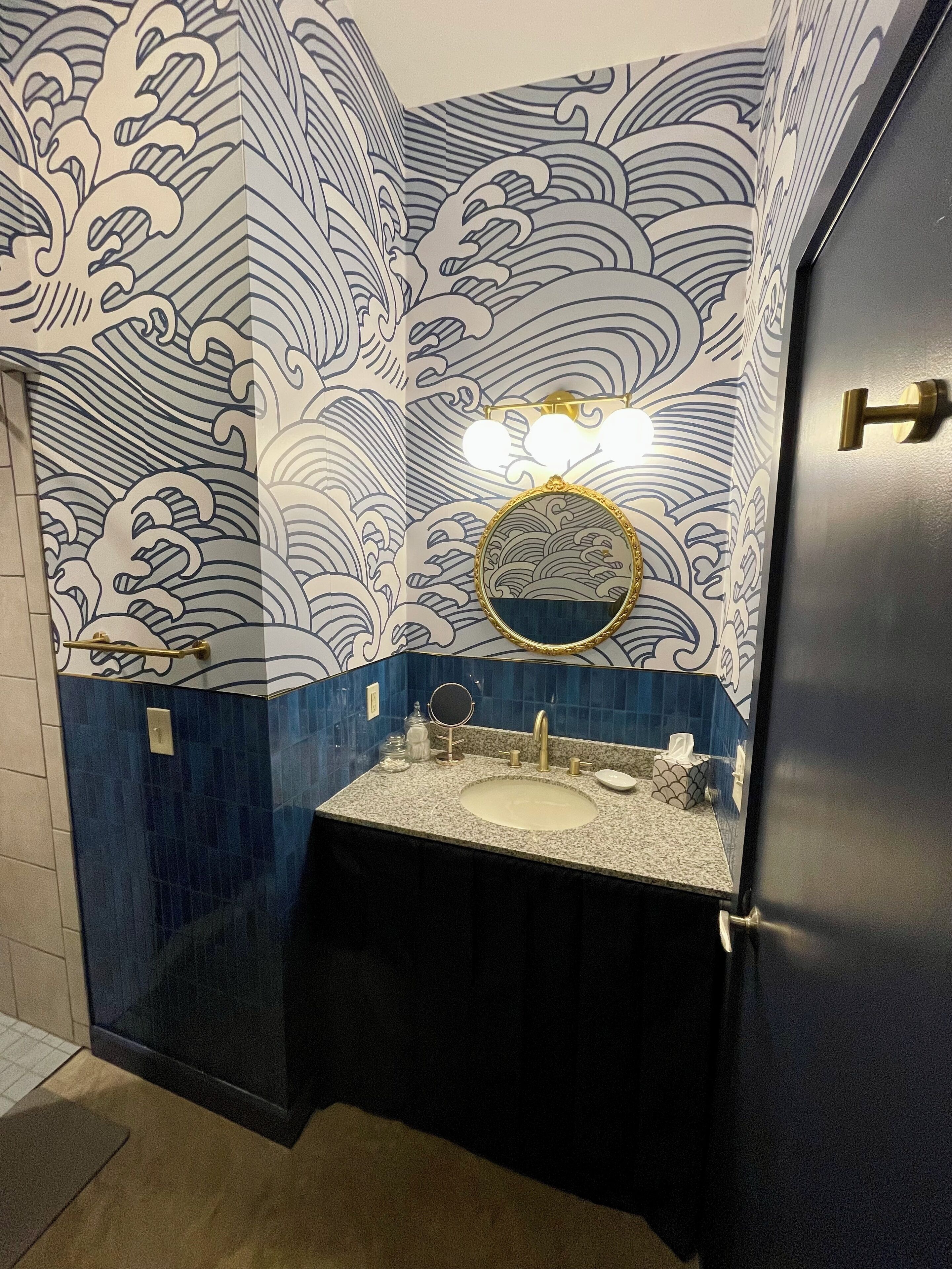 A bathroom with a sink, mirror, and towel rack.