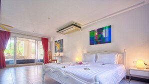 A spacious bedroom with a large bed, a desk, and a painting on the wall.