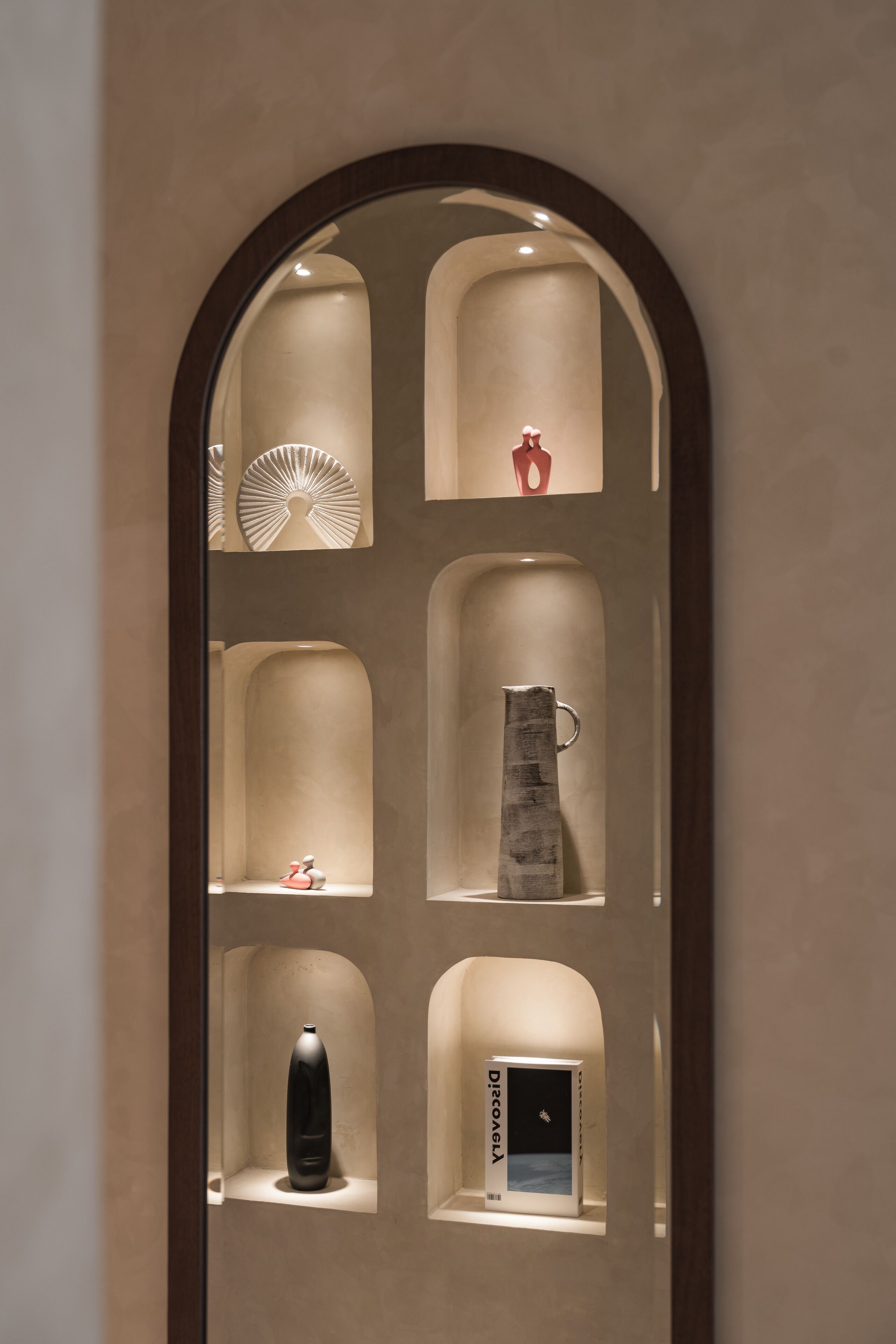 A wall with multiple display shelves containing various items.
