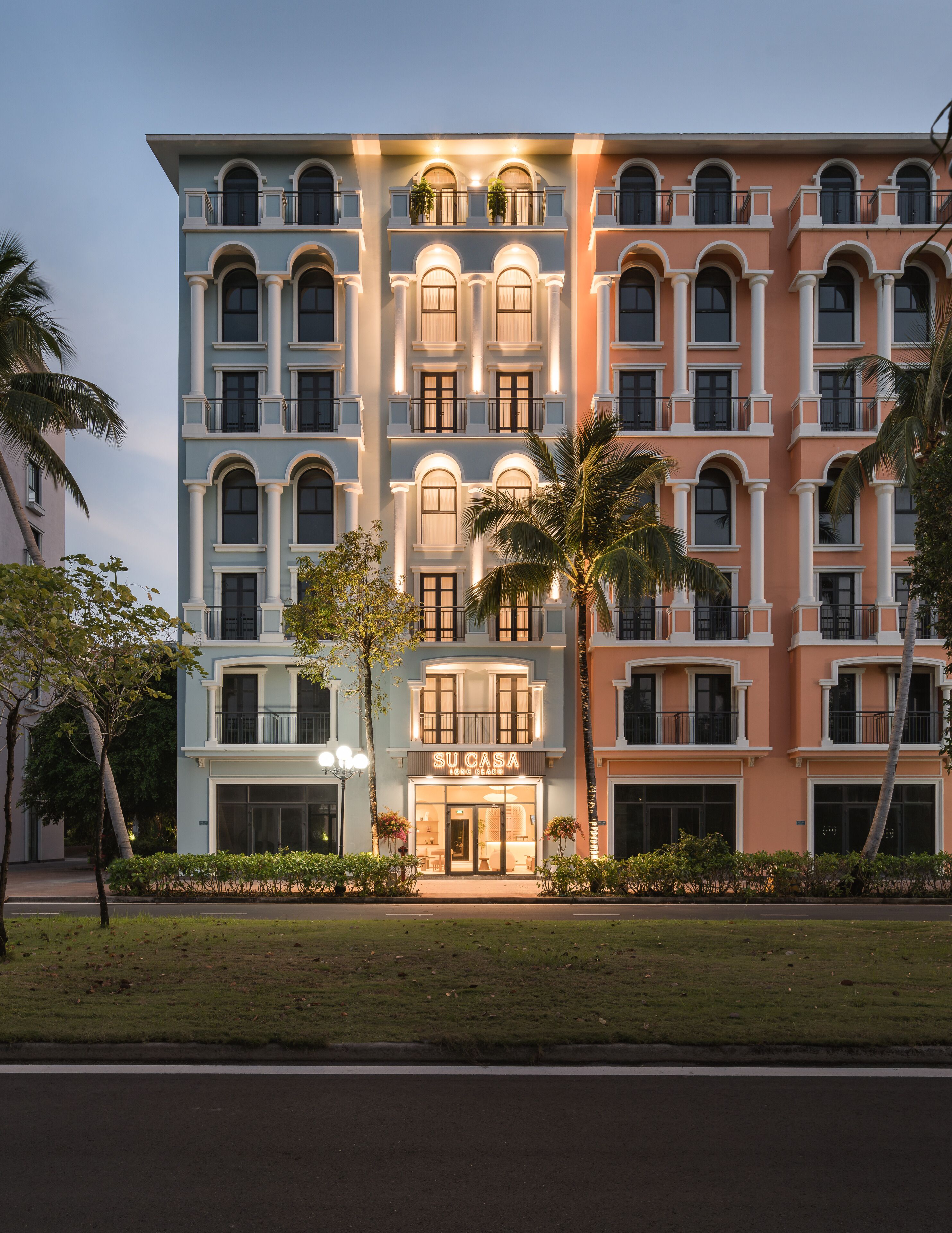 Un hotel de varios pisos con un diseño arquitectónico clásico, con ventanas y balcones arqueados.