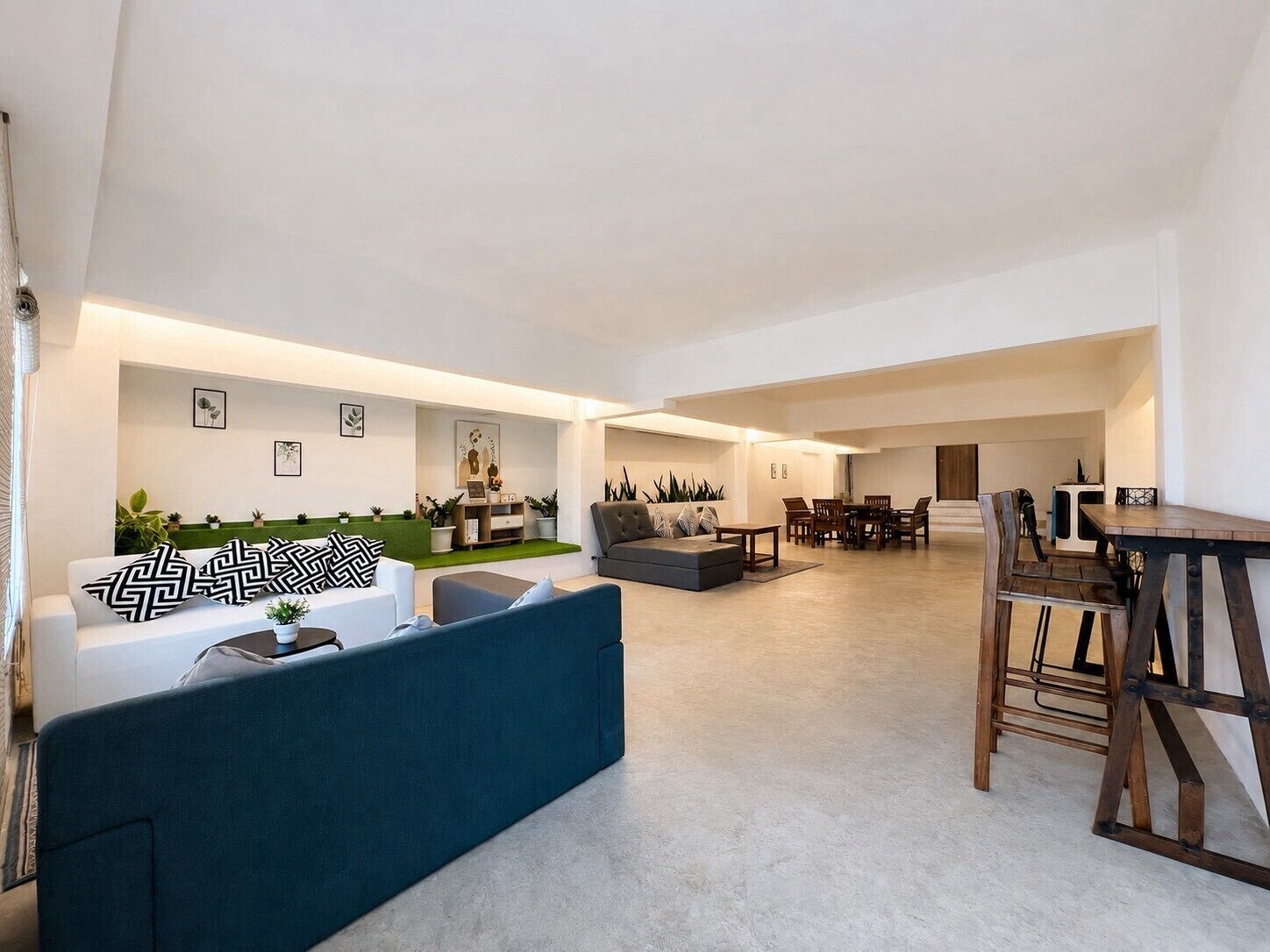 A spacious living area with a sofa, a dining table, and chairs.