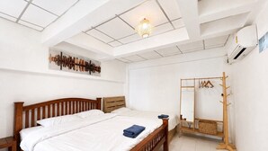 Un dormitorio con cama de madera, espejo en la pared y ventilador de techo.