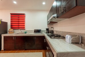 A modern kitchen with a gas stove, a coffee maker, and a toaster.