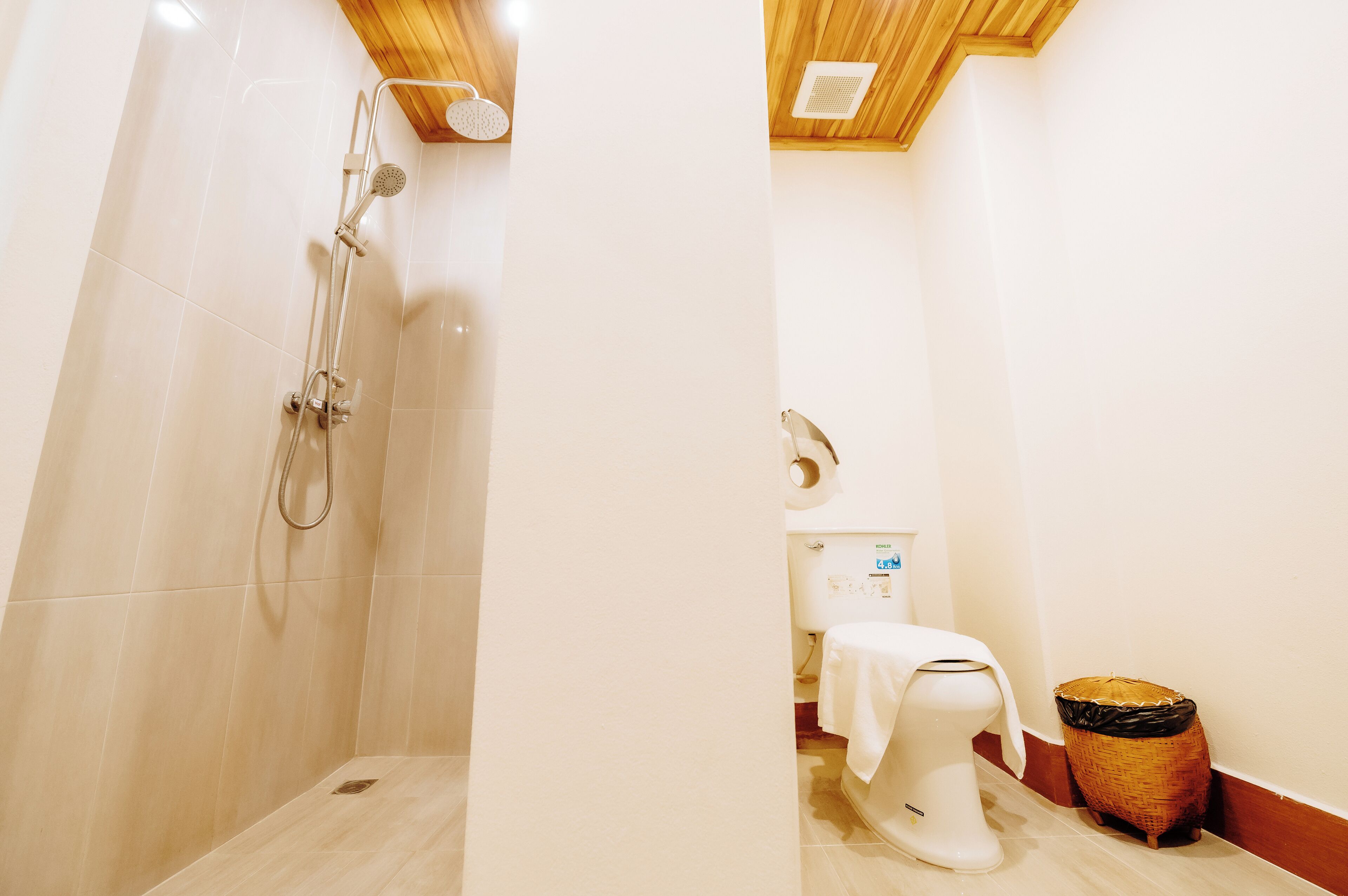 Ein Badezimmer mit Dusche, Toilette und Mülleimer.