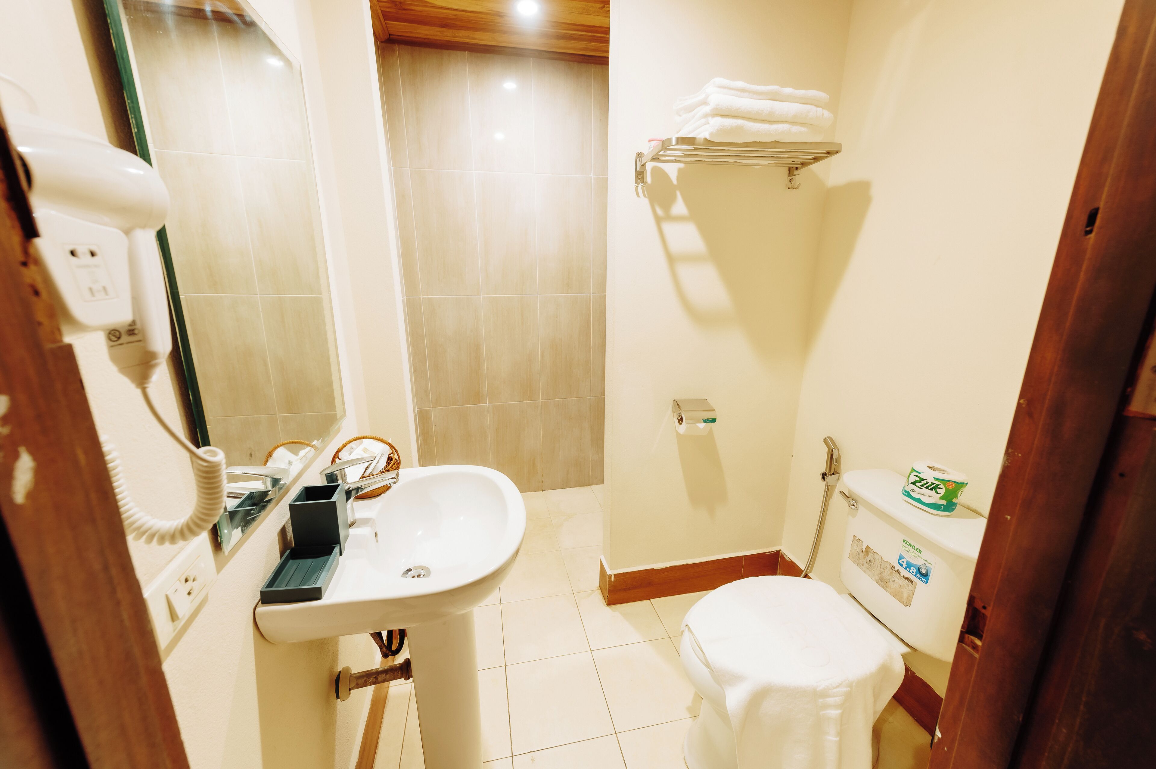 Un baño con lavamanos, inodoro y toallero.