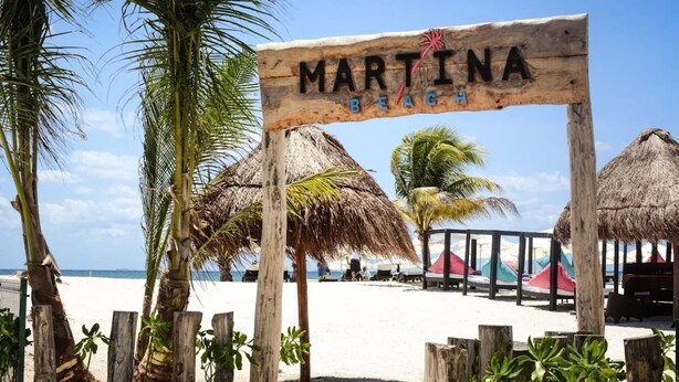 A wooden sign with 'MARTINA BEACH' written on it, surrounded by palm trees and beach umbrellas. - Gorgeous 8 People Basic Villa With Pool Playacar Phase 2 (Playa del Carmen)