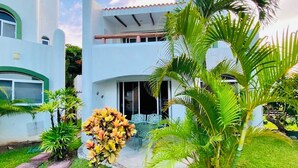A two-story building with a white exterior and a balcony. - Gorgeous 8 People Basic Villa With Pool Playacar Phase 2 (Playa del Carmen)