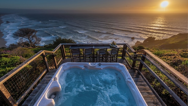 A hot tub on a wooden deck with a view of the ocean and sunset. - Oceanfront/ Stunning Views/ Hot Tub/ Contemporary (Manchester)