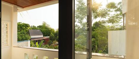 A balcony with a view of a house and trees.