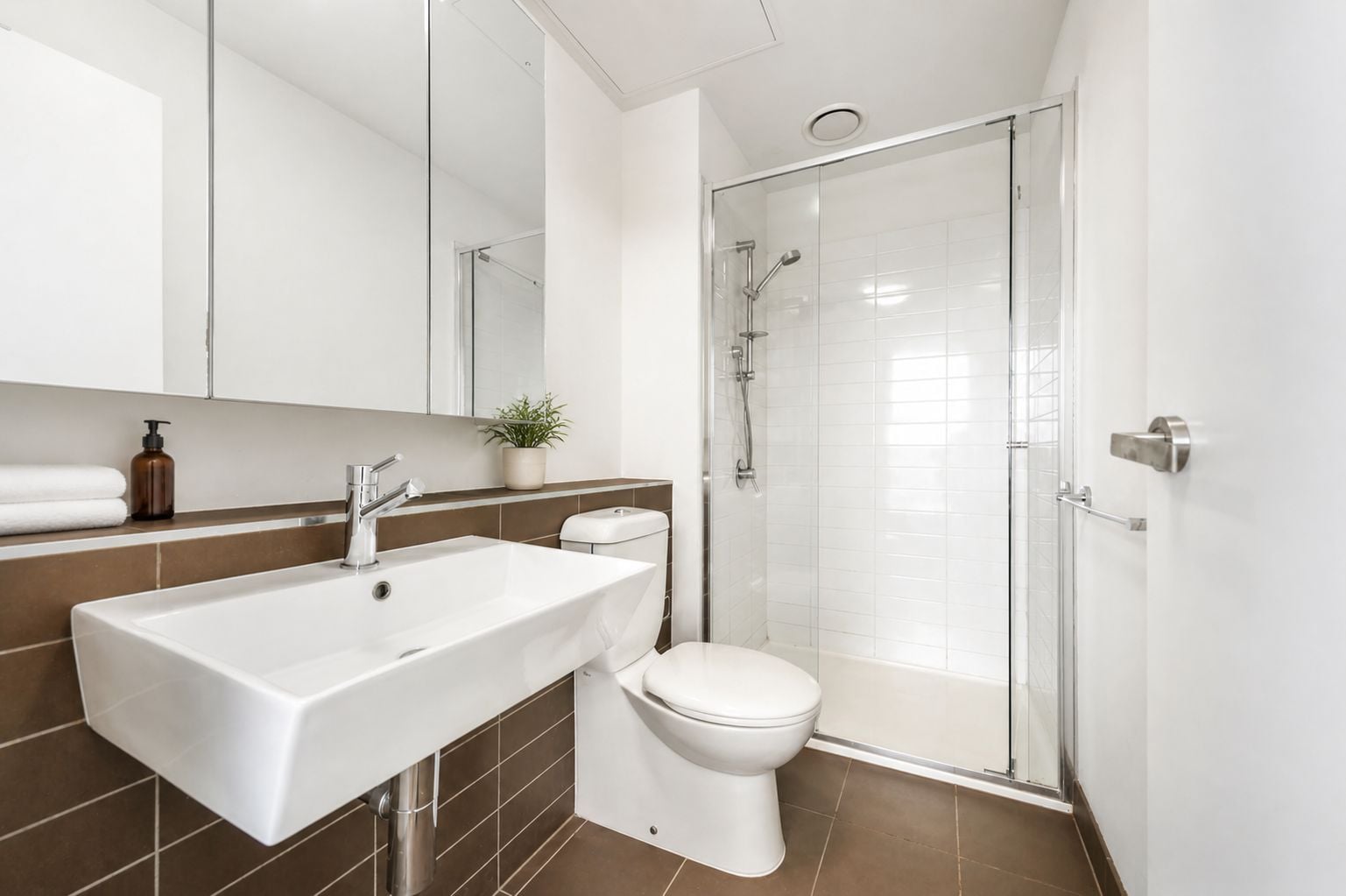 Un bagno moderno con lavandino ampio, toilette e cabina doccia in vetro.