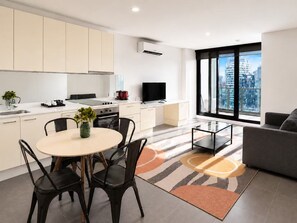 A modern apartment with a kitchen, dining area, and living room. - Sakura Apartment (Melbourne)
