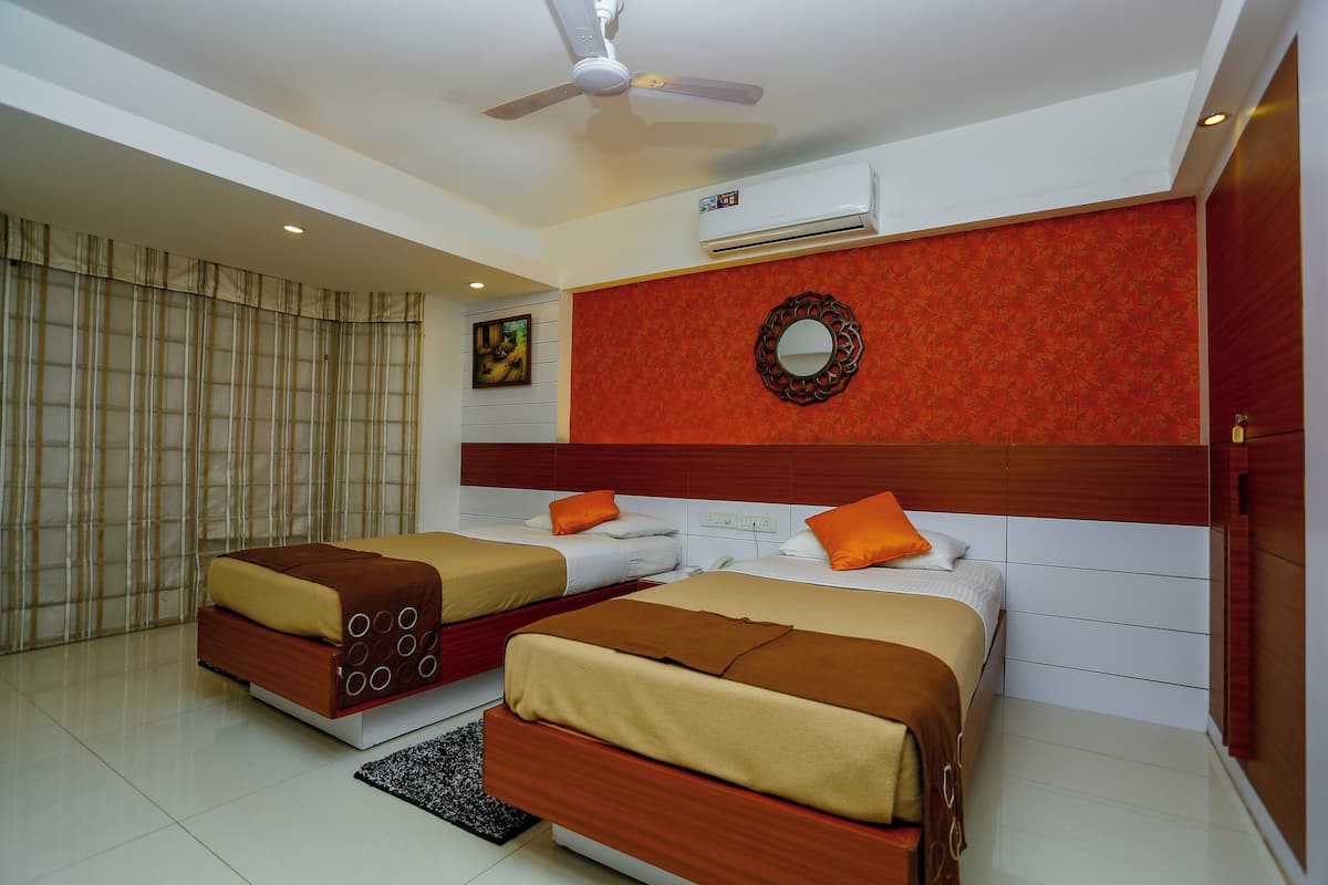 A hotel room with two beds, a ceiling fan, an air conditioning unit, a decorative mirror, and a window with curtains.