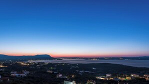 Uma vila costeira ao entardecer, com casas e vista para o mar.