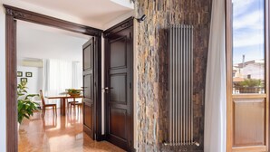 Ein modernes Interieur mit Wandverkleidung aus Stein, dunklen Holztüren und einem Essbereich mit Tisch und Stühlen.