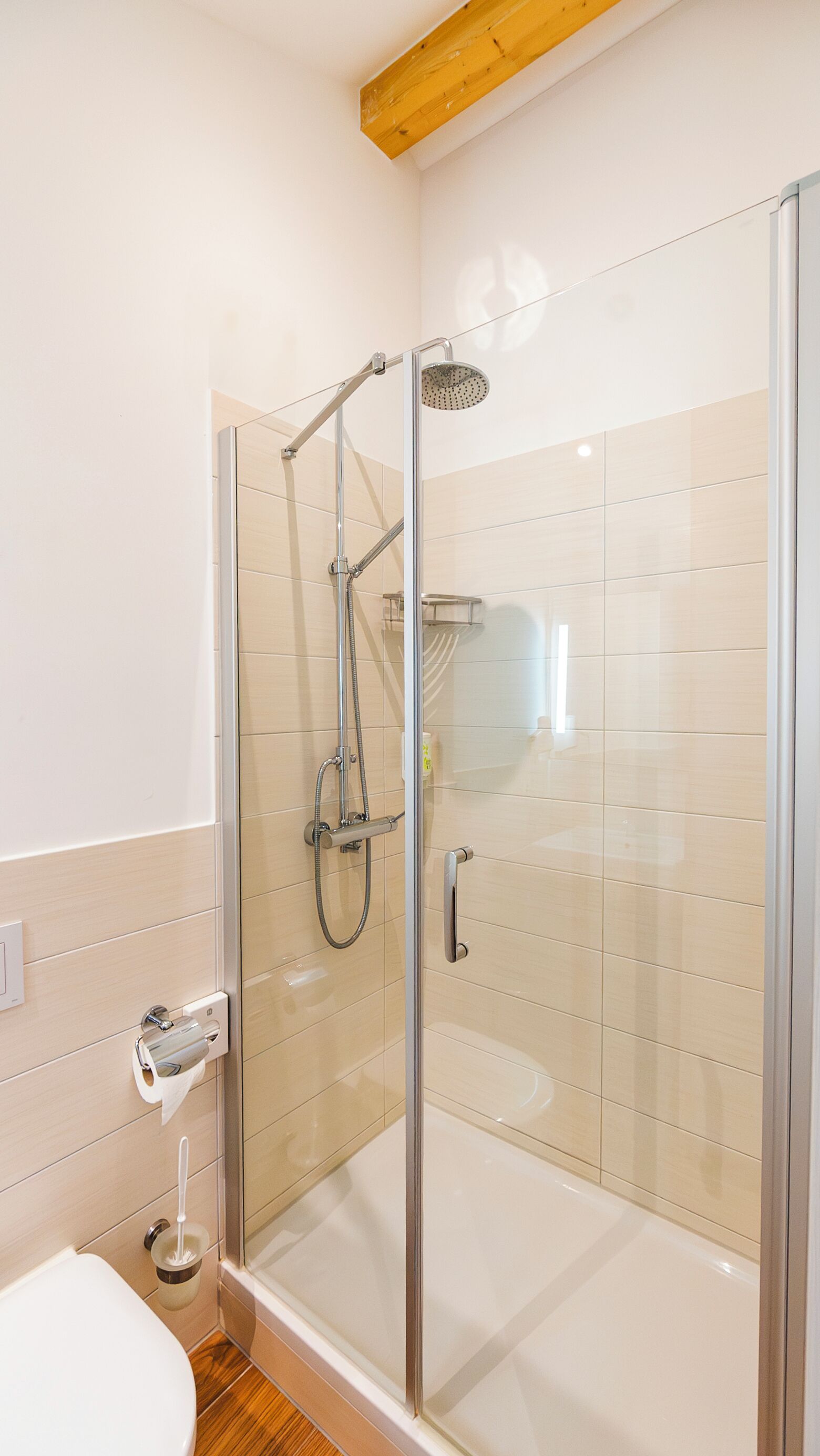 Ein modernes Badezimmer mit einer einteiligen Duschkabine, einer Toilette und einem Handtuchhalter.