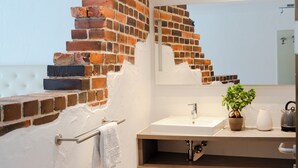 A bathroom with a white sink, a mirror, a towel rack, and a potted plant. - Henrys Sleeping Buttenwiesen (Buttenwiesen)
